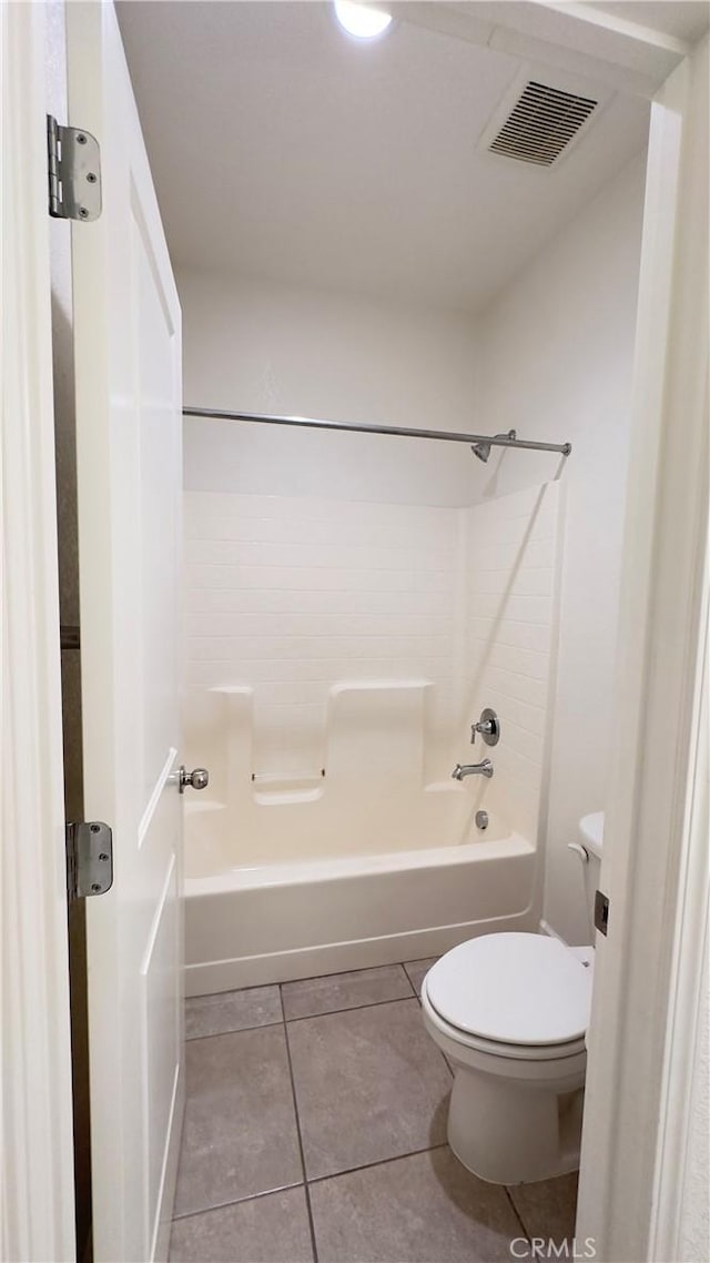 bathroom featuring toilet, tub / shower combination, and tile patterned flooring