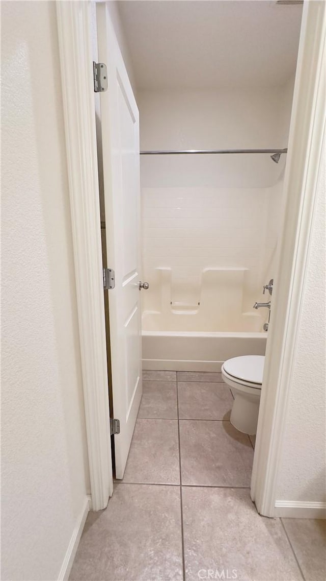 bathroom featuring shower / bath combination, tile patterned flooring, and toilet