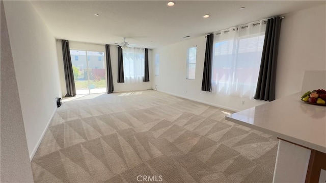 interior space featuring light carpet and ceiling fan