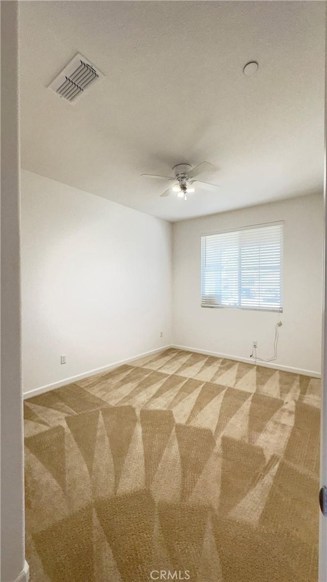 carpeted spare room with ceiling fan