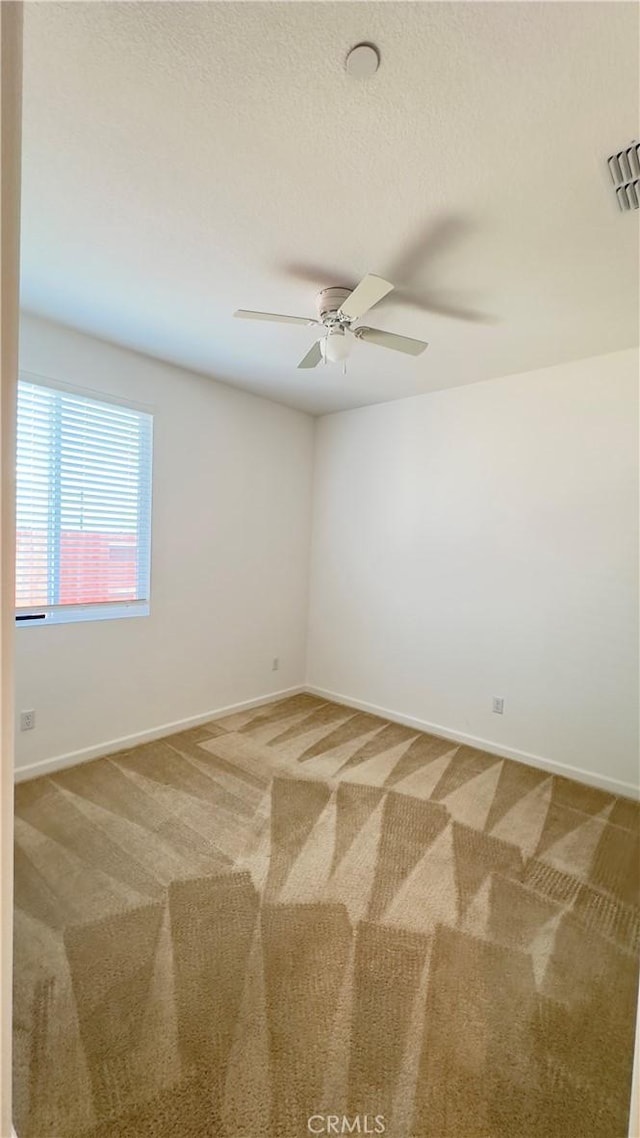 unfurnished room with ceiling fan and carpet flooring