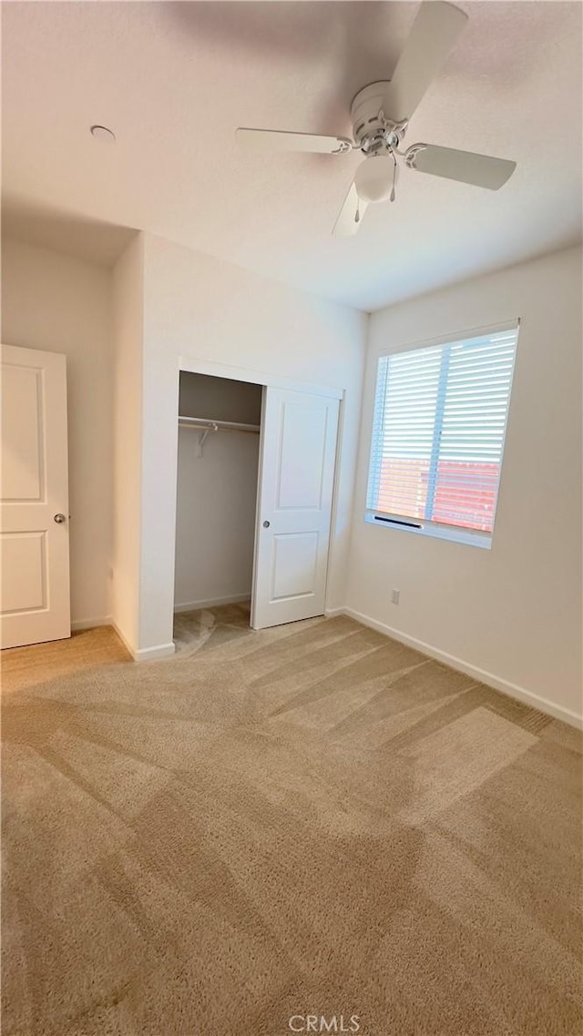 unfurnished bedroom with a closet, ceiling fan, and carpet