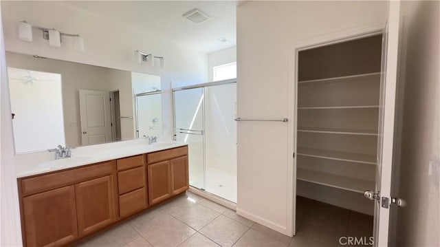 bathroom with tile patterned flooring, vanity, and a shower with shower door