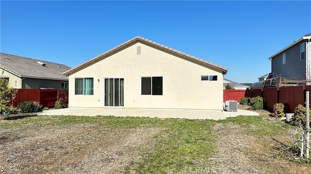 rear view of house with a yard, central AC unit, and a patio area