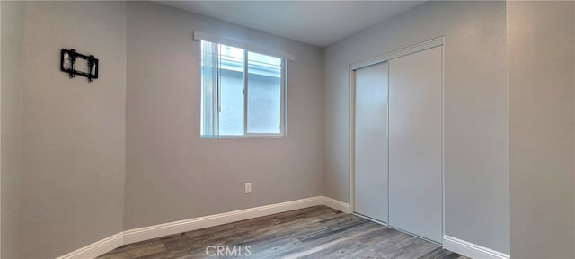 unfurnished bedroom featuring a closet and hardwood / wood-style flooring