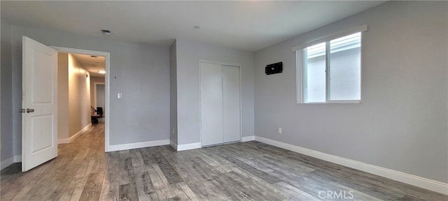 unfurnished bedroom with wood-type flooring and a closet