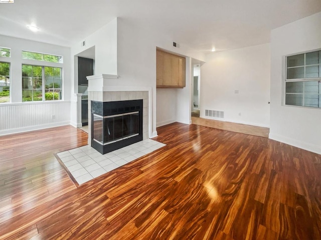 unfurnished living room with light hardwood / wood-style floors and a tile fireplace