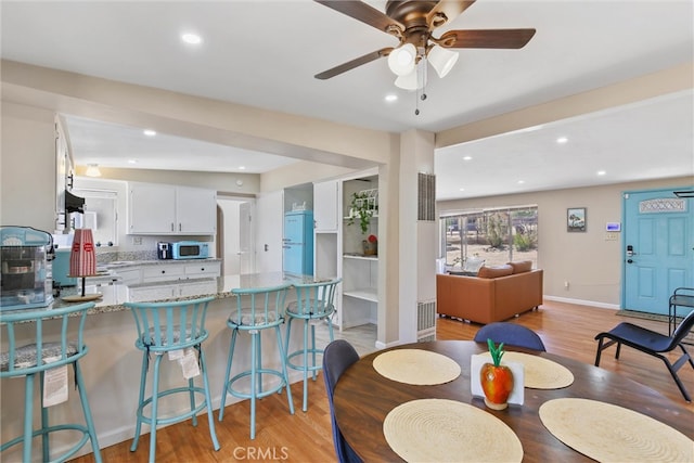 dining area featuring light hardwood / wood-style flooring and ceiling fan