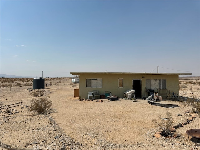 back of property featuring a rural view and a patio area