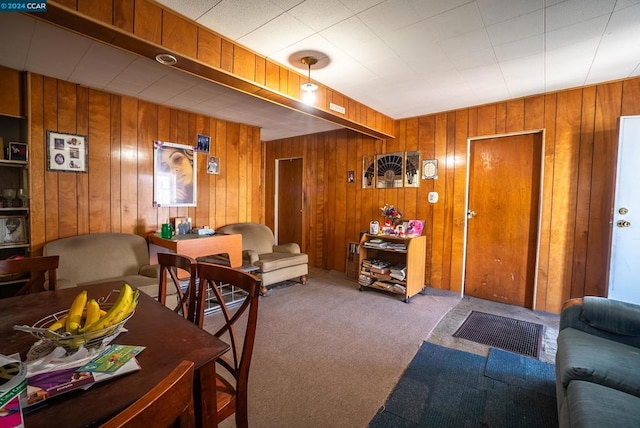 carpeted living room featuring wood walls