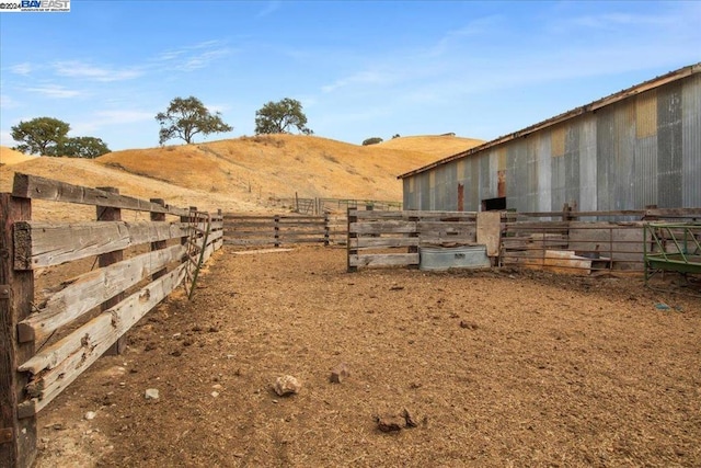 view of yard with a mountain view, a rural view, and an outbuilding