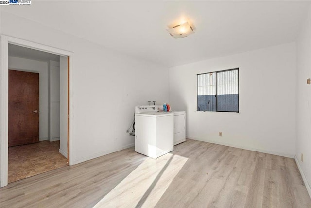 laundry room with light wood-type flooring and washer and clothes dryer