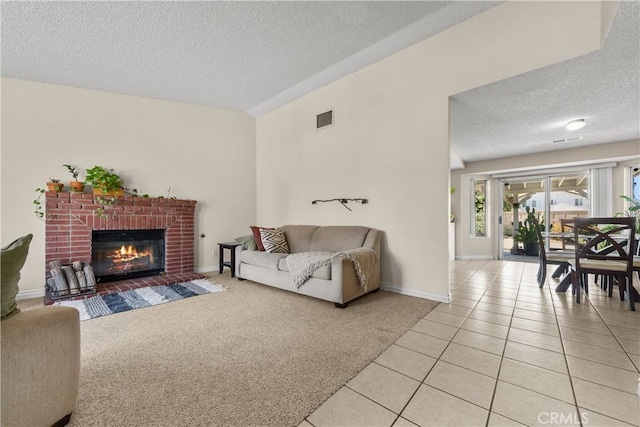 living room featuring a fireplace, a textured ceiling, and light tile patterned flooring