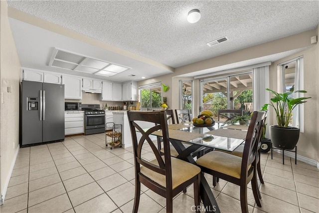 dining area with a textured ceiling and light tile patterned flooring