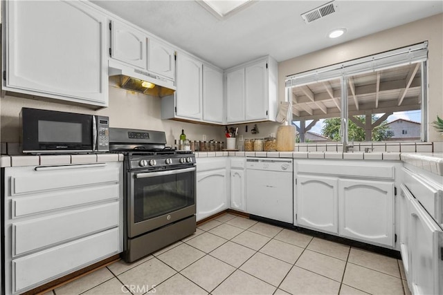 kitchen with dishwasher, white cabinetry, tile counters, and stainless steel range with gas stovetop