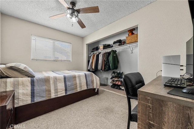 carpeted bedroom featuring ceiling fan, white fridge, a textured ceiling, and a closet