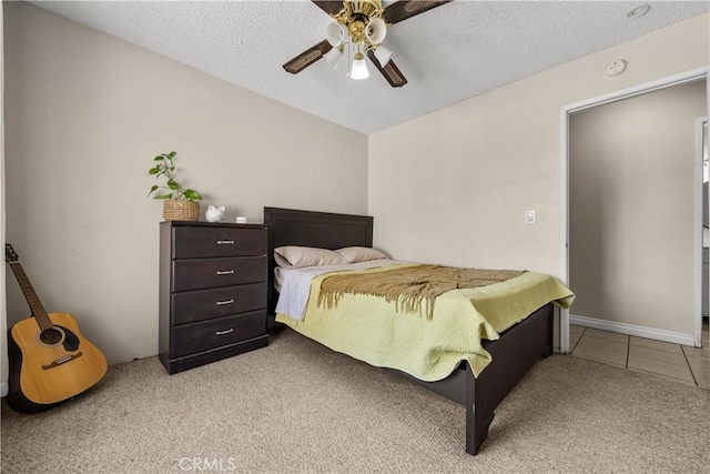 bedroom featuring light carpet, a textured ceiling, and ceiling fan