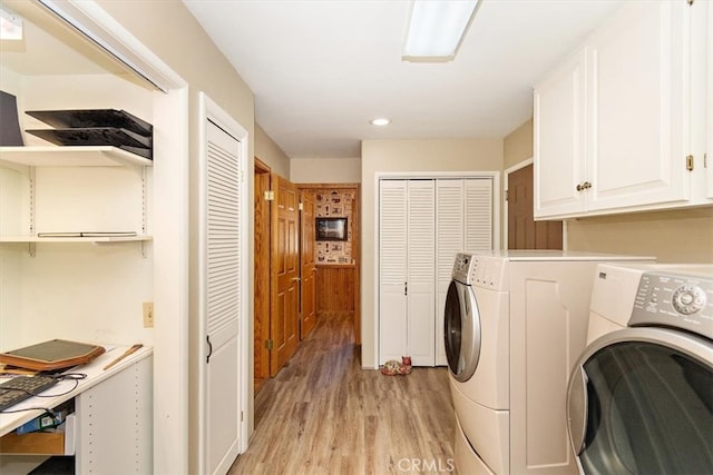 laundry room with cabinets, independent washer and dryer, and light hardwood / wood-style flooring