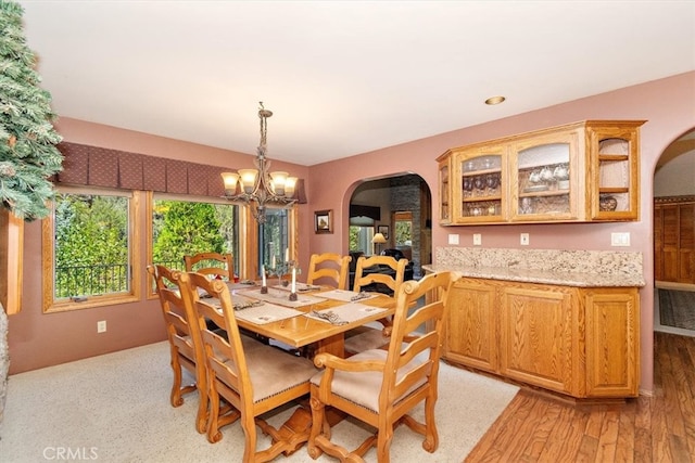 dining area with light wood-type flooring and a chandelier