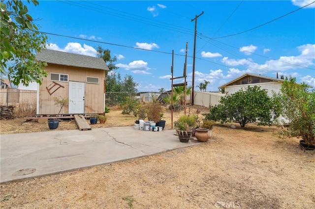 view of yard featuring a storage unit and a patio area