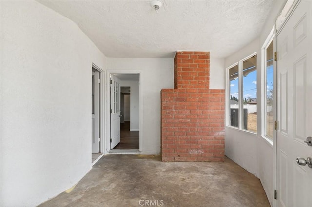 unfurnished room with concrete flooring and a textured ceiling