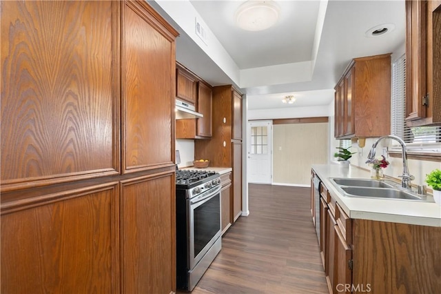 kitchen featuring stainless steel gas stove, sink, and dark wood-type flooring