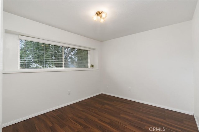 unfurnished room with dark wood-type flooring