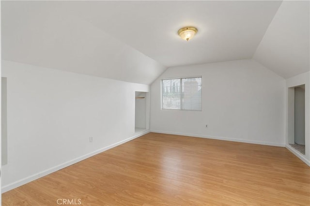 additional living space featuring light hardwood / wood-style floors and lofted ceiling