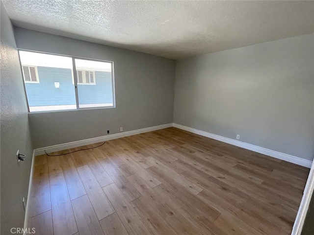 empty room featuring light hardwood / wood-style floors and a textured ceiling