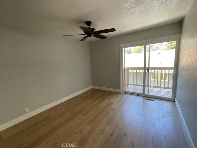 empty room featuring hardwood / wood-style floors, ceiling fan, and a textured ceiling