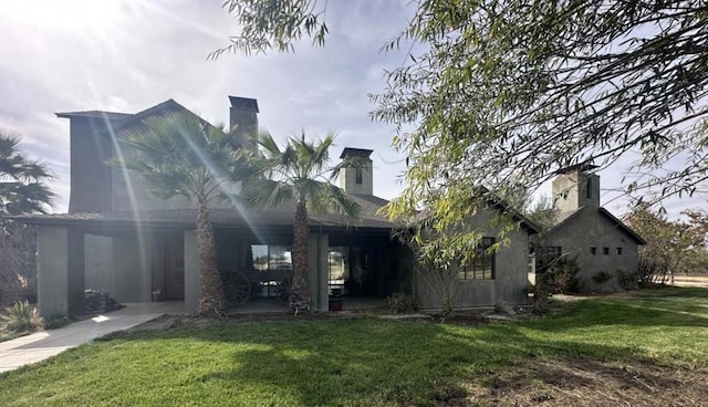 rear view of property with a patio area and a yard