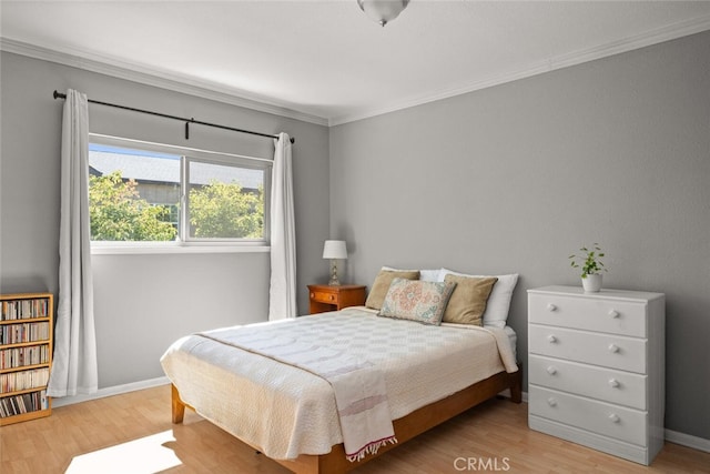 bedroom featuring light wood-type flooring and crown molding