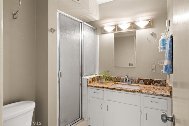 bathroom featuring walk in shower, vanity, and toilet