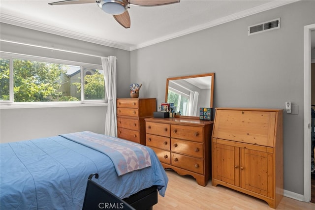 bedroom featuring ornamental molding, light wood-type flooring, visible vents, and multiple windows