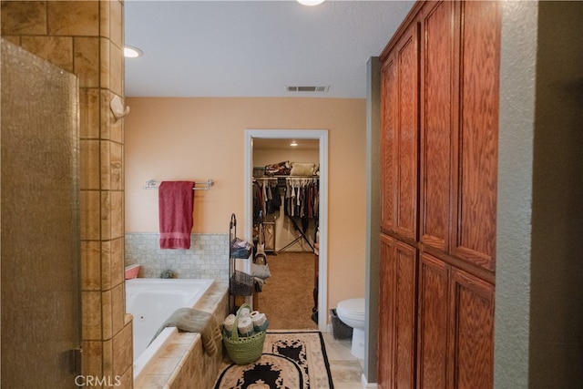 bathroom featuring independent shower and bath, tile patterned flooring, and toilet