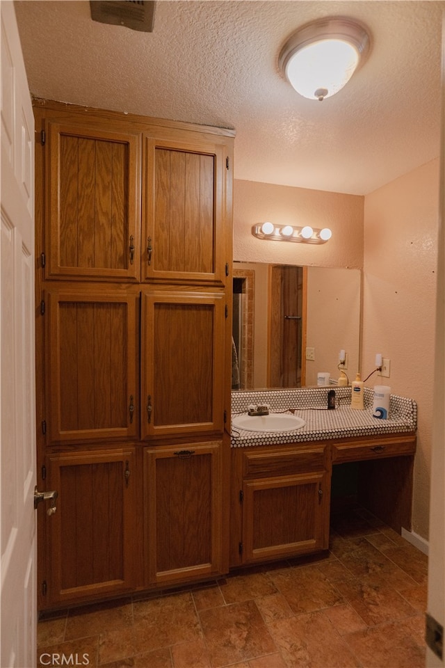 bathroom with a textured ceiling and vanity