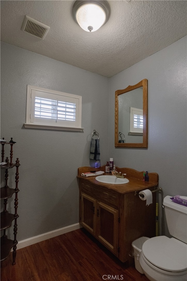 bathroom featuring a textured ceiling, hardwood / wood-style flooring, vanity, and toilet