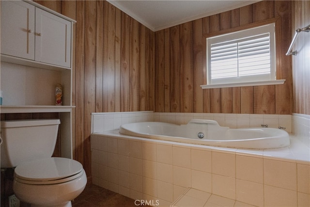 bathroom with tile patterned flooring, wood walls, tiled bath, and toilet