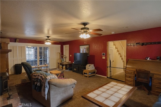 carpeted living room featuring ceiling fan and a textured ceiling