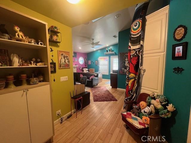 game room featuring vaulted ceiling, built in features, ceiling fan, and light hardwood / wood-style floors