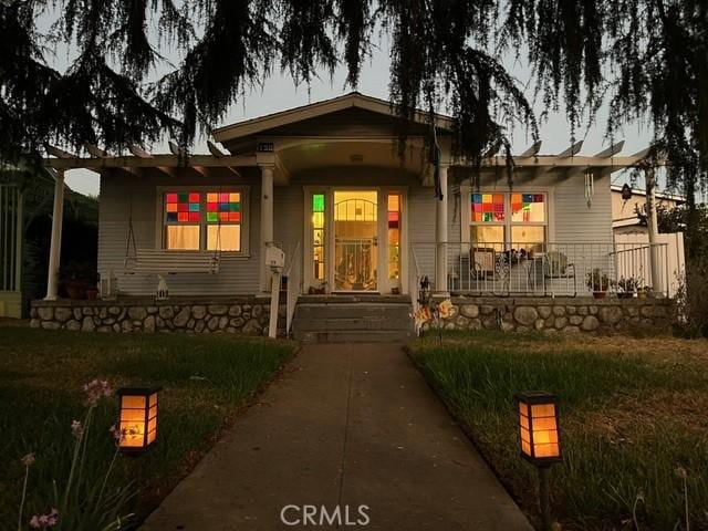 view of front of house featuring covered porch and a front lawn