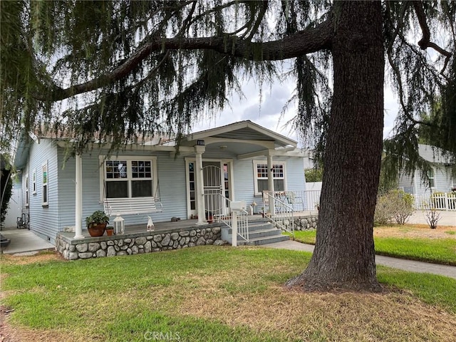 view of front of property featuring a front yard and covered porch