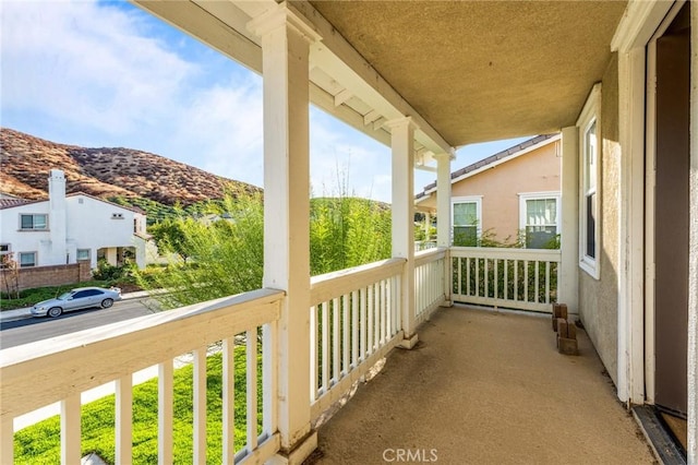 balcony featuring a mountain view and covered porch