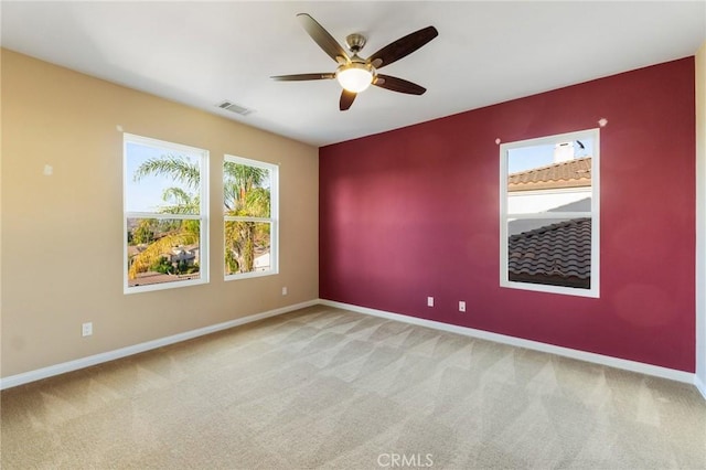 empty room featuring ceiling fan and light colored carpet