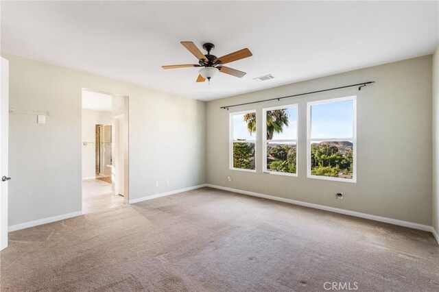 carpeted spare room featuring ceiling fan