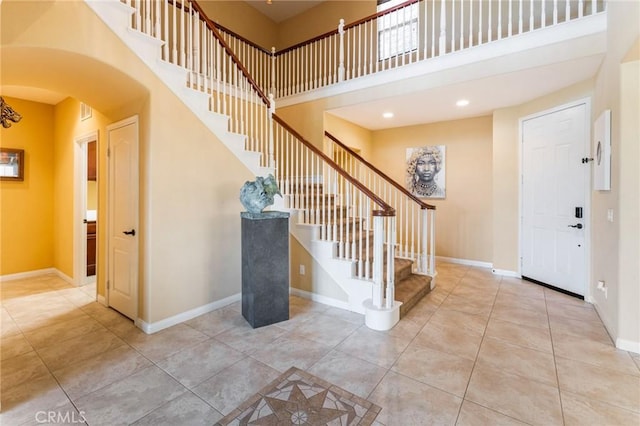 entryway featuring light tile patterned floors and a high ceiling