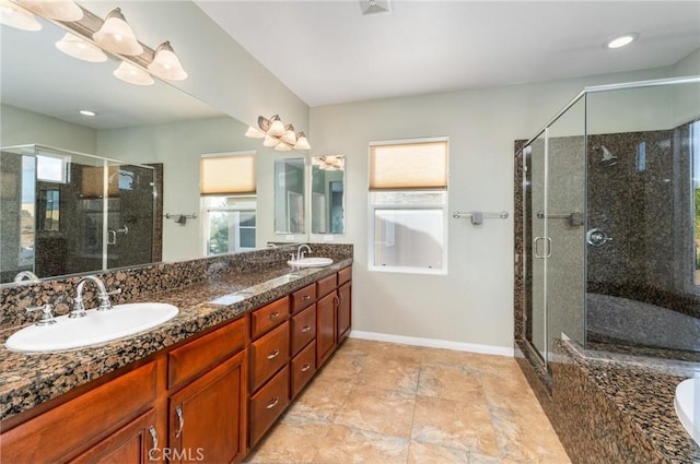 bathroom featuring plenty of natural light, a shower with shower door, and vanity