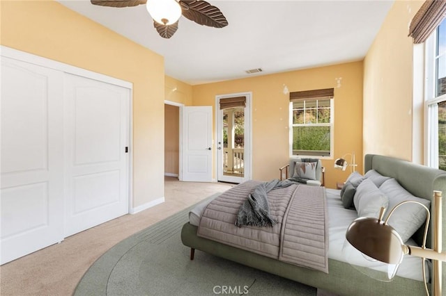 bedroom featuring light carpet, access to exterior, a closet, and ceiling fan