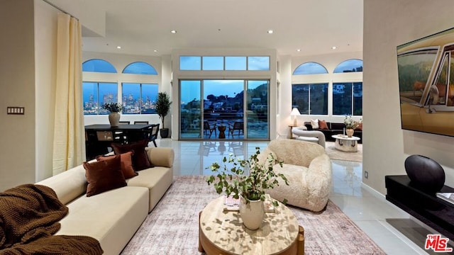 living room with a towering ceiling and light tile patterned floors