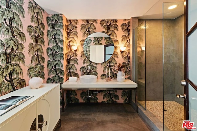 bathroom featuring a tile shower and vanity